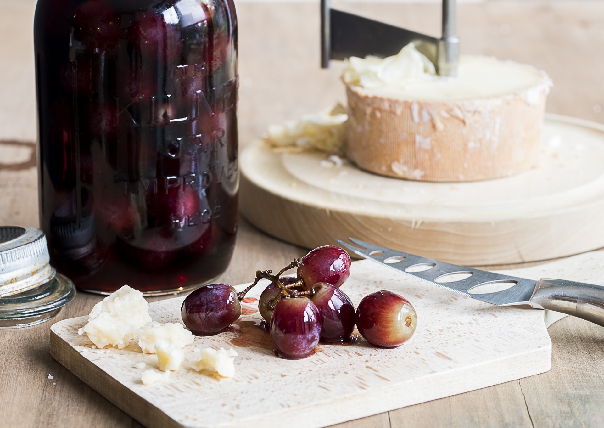pickled grapes in a Kilner jar with a cheese board and cheese cutter