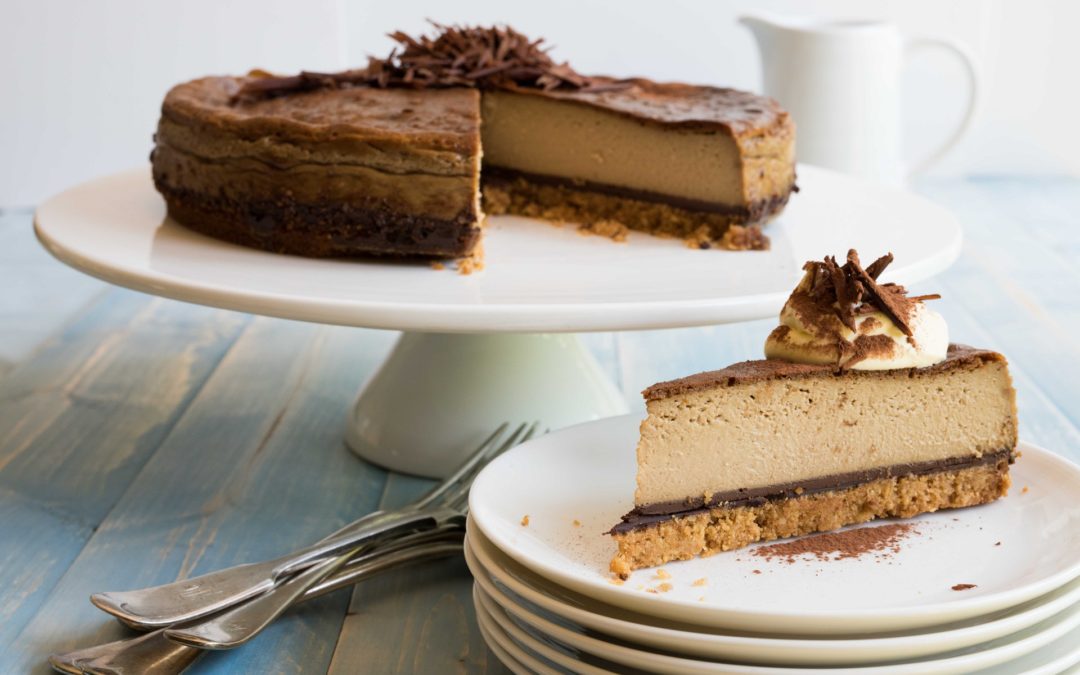 a cake stand with a portion of coffee flavoured cheesecake topped with dark chocolate shavings