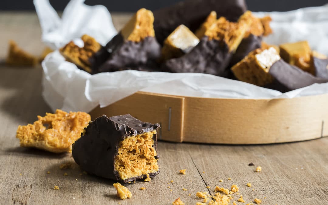 A box of homemade honeycomb, broken into chunks and dipped in dark chcoclate