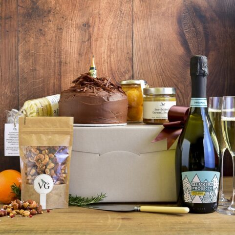 a celebration hamper with chocolate cake and prosecco